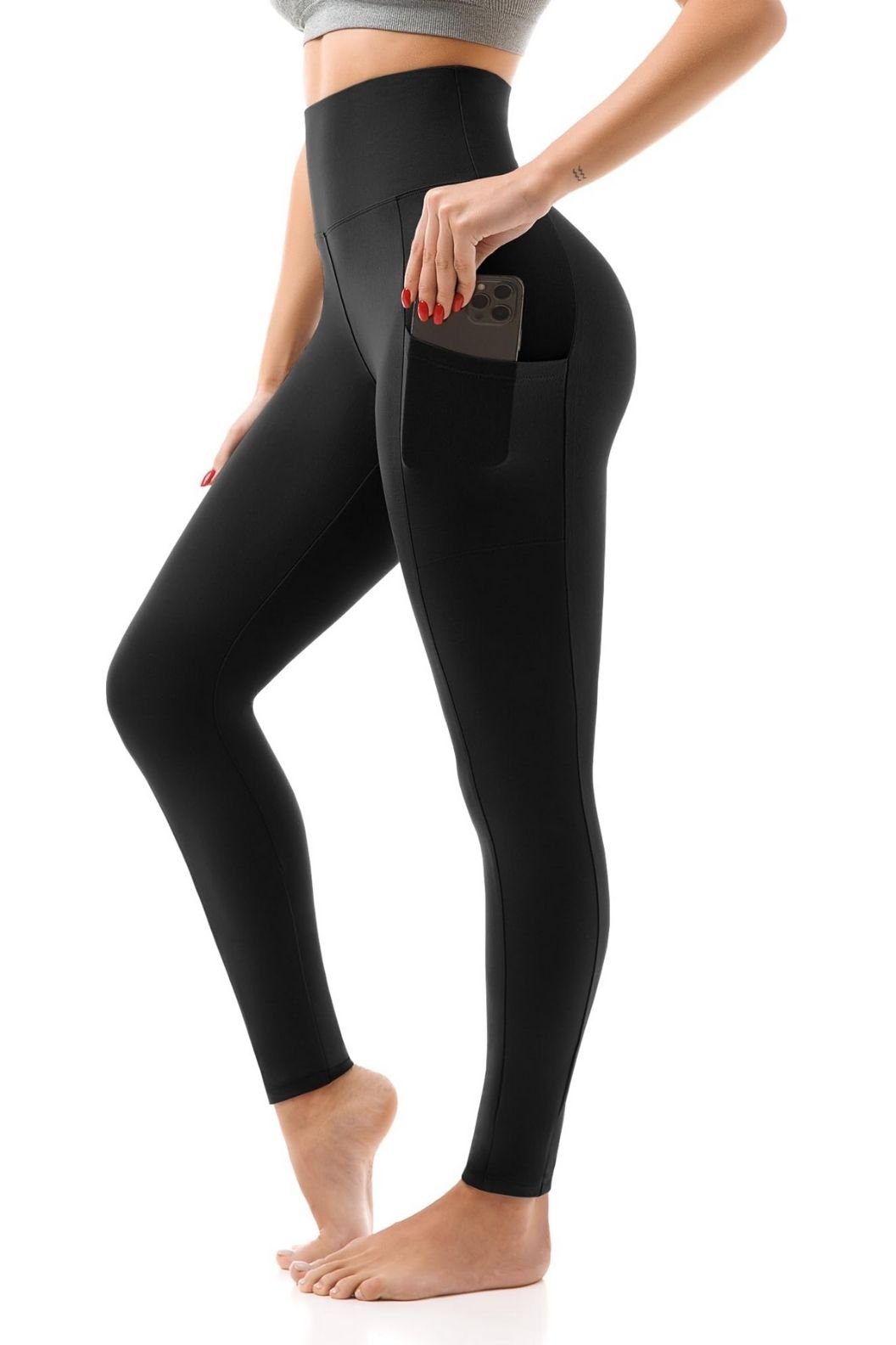 A woman in black leggings with a phone in the pocket, showcasing a side view of her outfit.