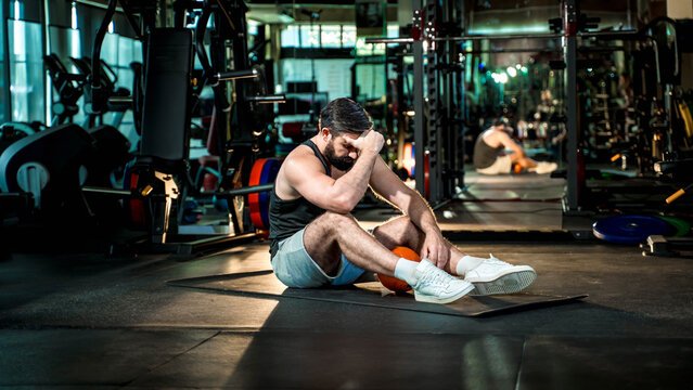 Man Stretching with Foam Roller in Gym