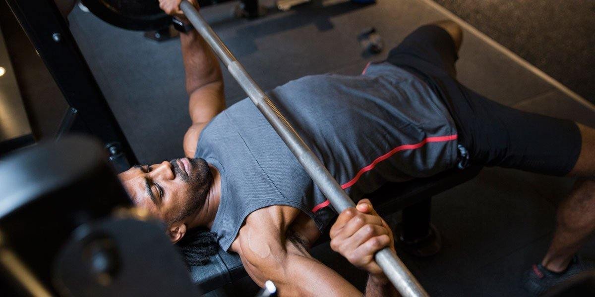 Man Doing Bench Press Exercise in Gym