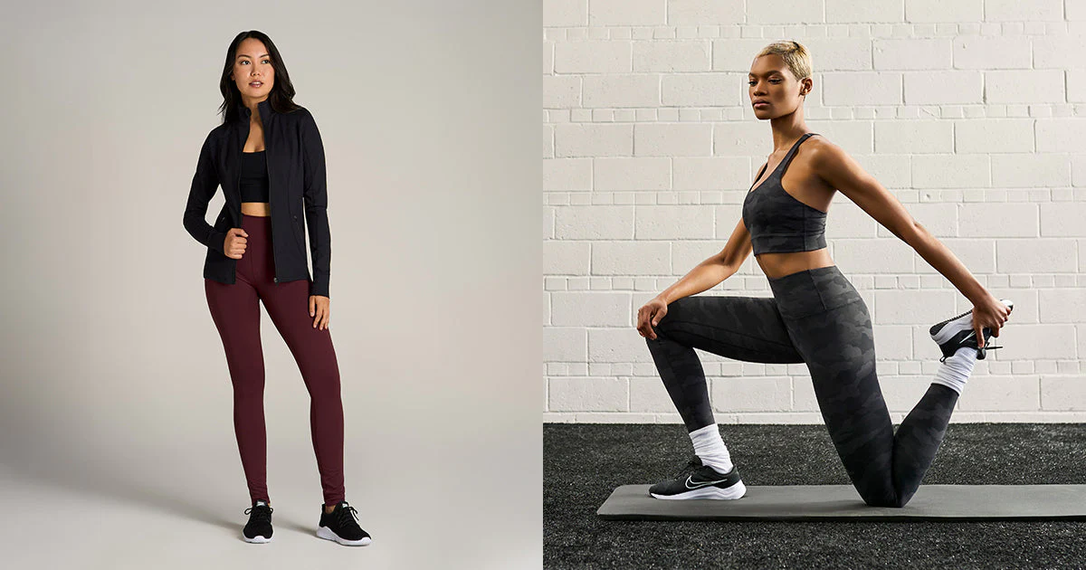 Two women wearing stylish activewear sets — one in a black sports bra, burgundy leggings, and a zip-up jacket; the other in a black camo matching sports bra and leggings set while stretching on a mat indoors.